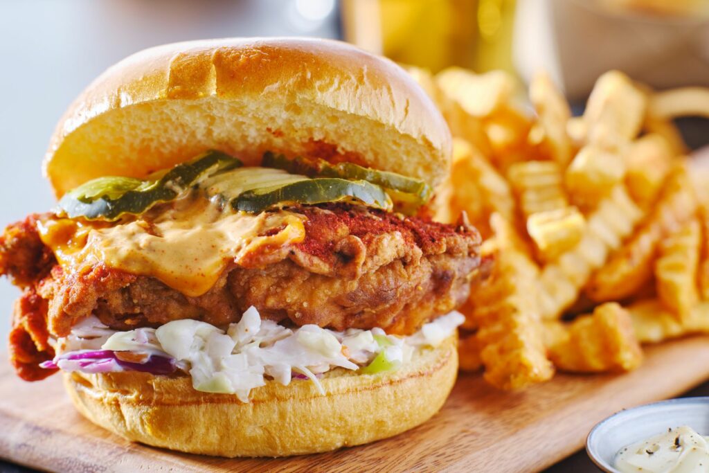 For Those Who Relish in Luxury - fried chicken sandwich served with fries on a wooden platter